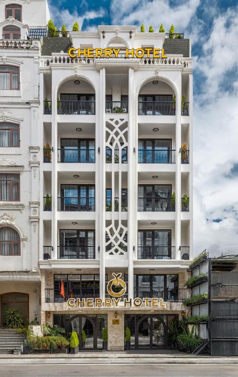 a white hotel with a sign on the front of it at Cherry Đà Lạt 3 - Luxury Hotel in Da Lat