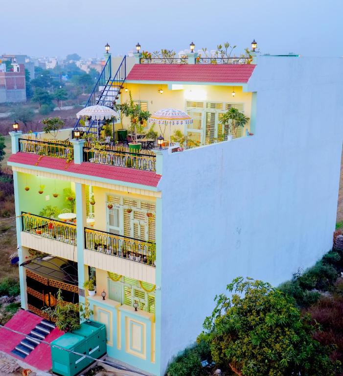 a white building with balconies and tables on it at The Gulmohar Villa in Tājganj