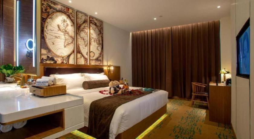 a bedroom with a large bed and a desk in it at James Joyce Coffetel· Wuhan Wangjiawan Taojialing Metro Station in Wuhan