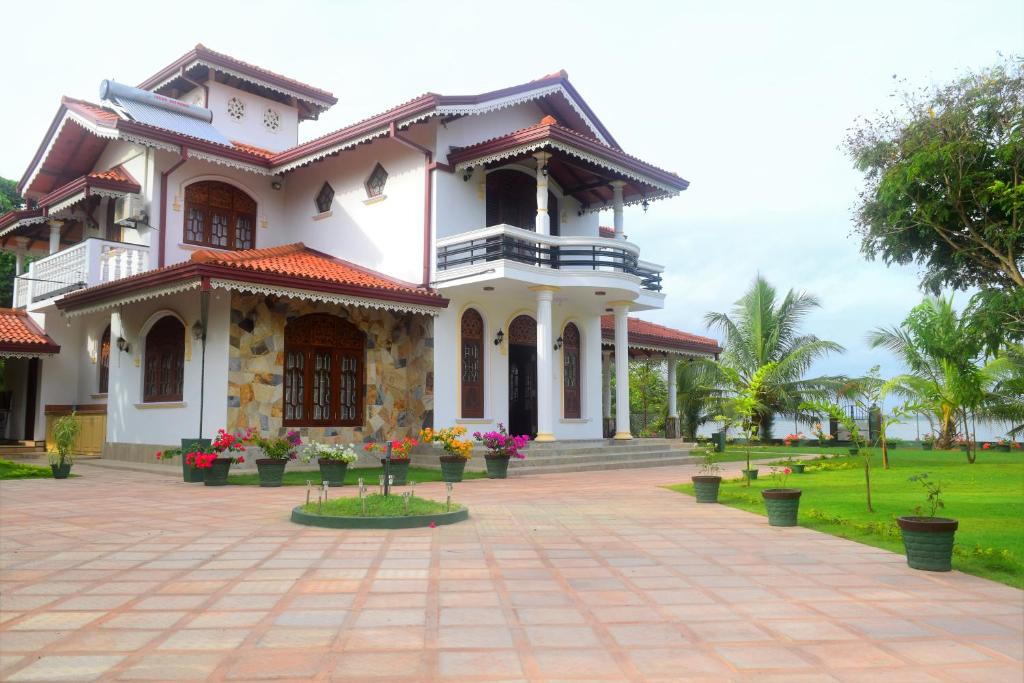 a white house with flowers in front of it at Sri Lagoon Villa in Negombo