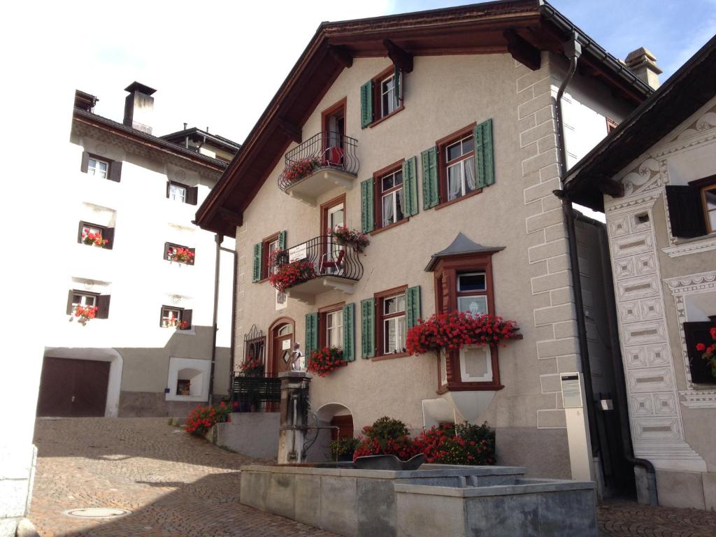 a building with flowers on the balconies of it at B&B Hotel & Appartements Chasa Valär in Scuol