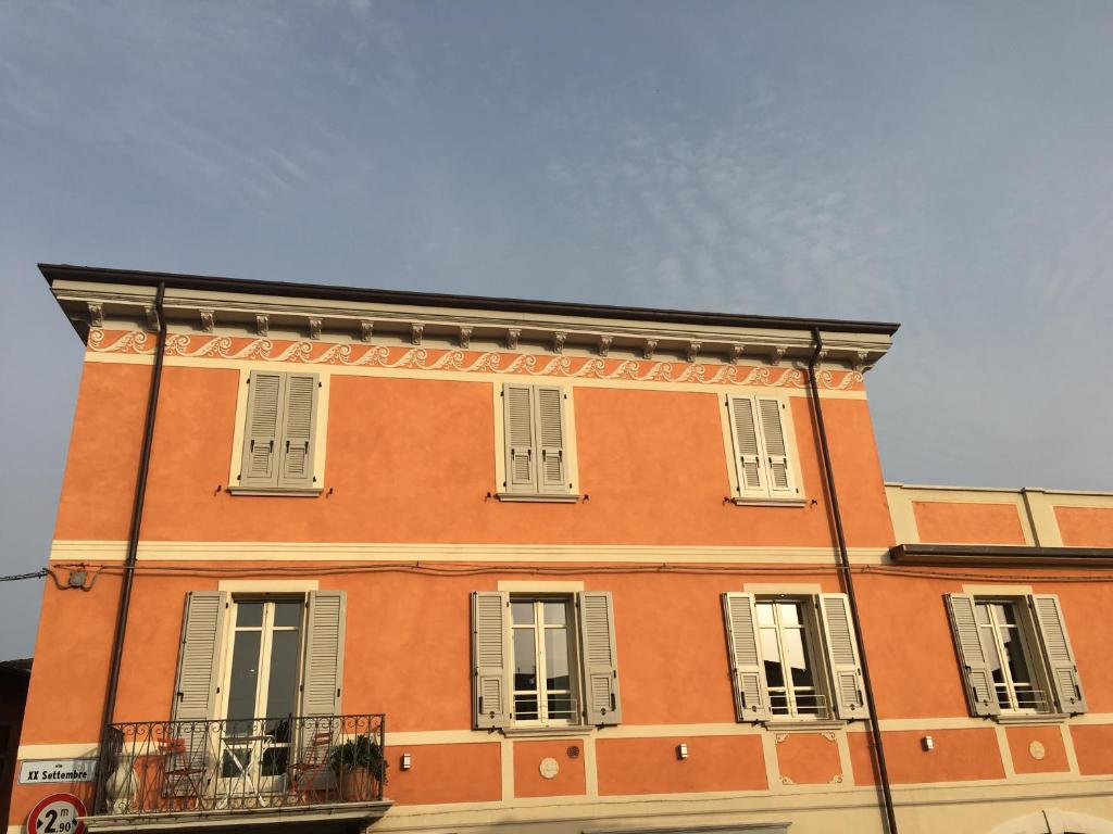 a large orange brick building with white shuttered windows at Piccolo Palazzo in San Felice del Benaco