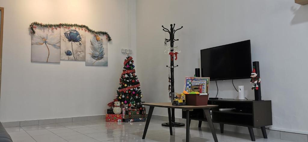 a living room with a christmas tree and a tv at Hey homestay melaka in Melaka
