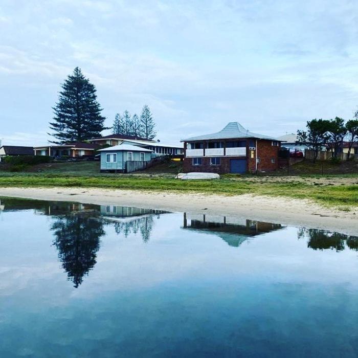 a reflection of a house in a body of water at Harrington Haven in Harrington