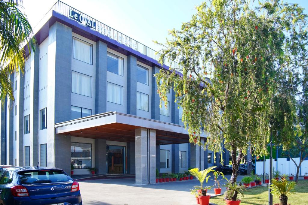 een blauwe auto geparkeerd voor een gebouw bij Le OVAL Hotel & Resorts in Nakraunda