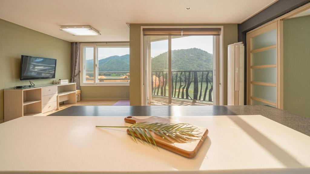 un soggiorno con un tavolo e una grande finestra di Gapyeong Applerotgi Pension a Gapyeong