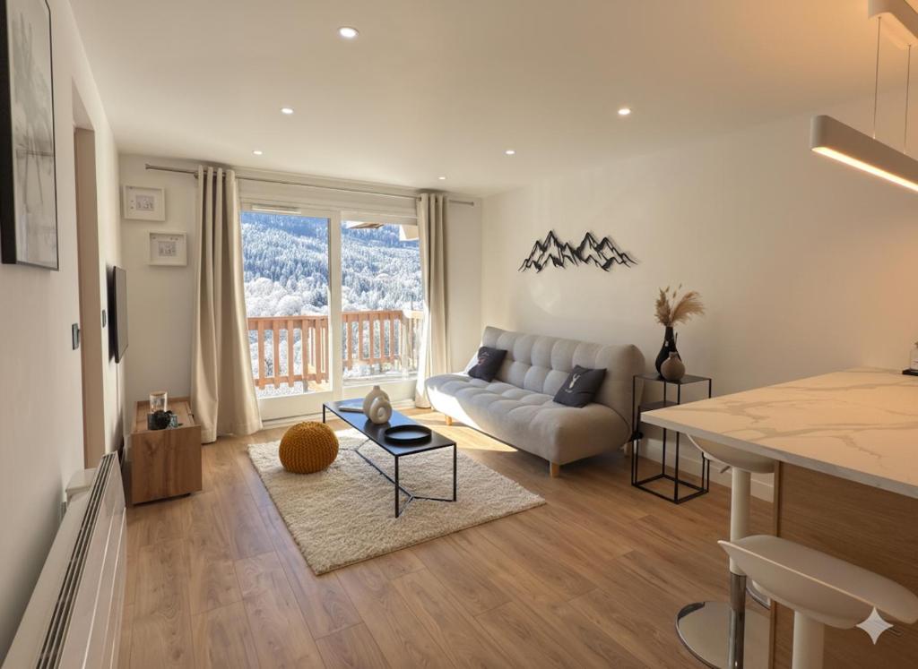 a living room with a couch and a table at Appartement rénové à Méribel Centre, avec Balcon et à 5 minutes des pistes et du centre in Méribel