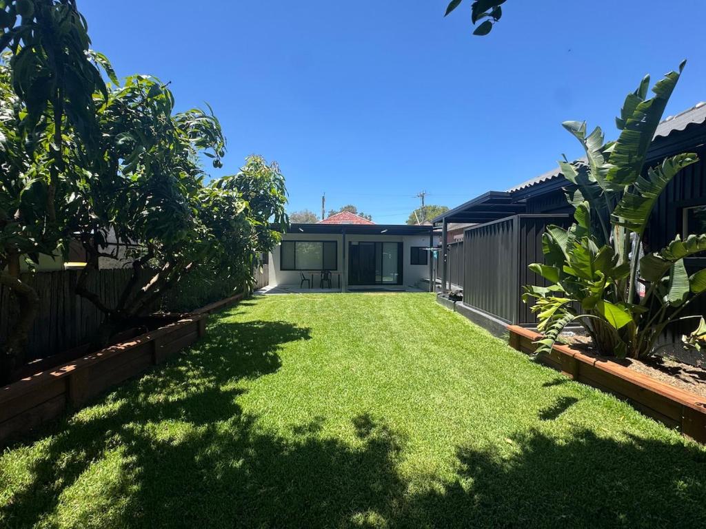 einen Hof mit grünem Gras und einem Haus in der Unterkunft HOME away from HOME in Sydney