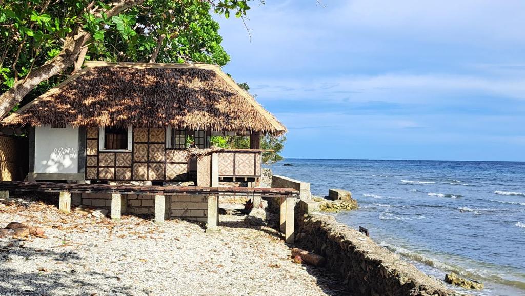 een hut op het strand bij het water bij Paseo Del Mar Seaside Inn in Jagna