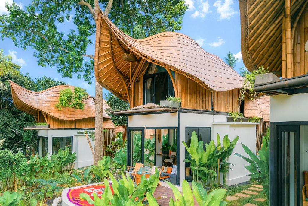 an image of a house with a large roof at Bamboo Asri Ubud in Ubud