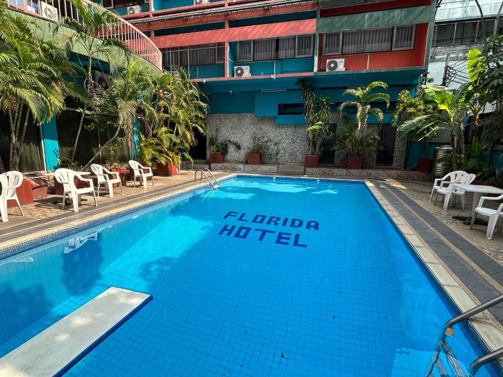 une piscine avec un panneau d'hôtel à côté d'un bâtiment dans l'établissement Florida Hotel, à Bangkok