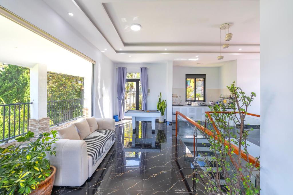 a living room with a couch and some plants at Cocovilla Đà Lạt in Ấp Ða Lợi
