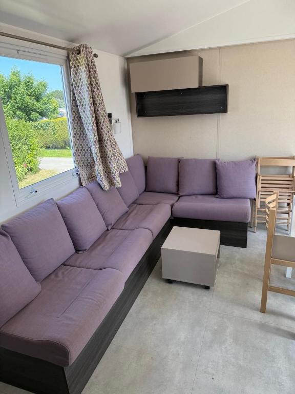 - un canapé violet dans le salon avec une fenêtre dans l'établissement Sevservices à La Réserve, à Gastes