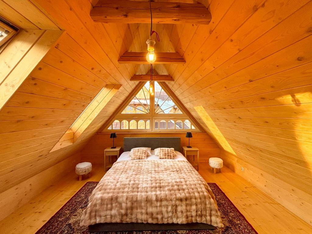 een slaapkamer met een bed op een houten zolder bij Willa Maciejówka Historyczny Dom Góralski przy Równi Krupowej in Zakopane