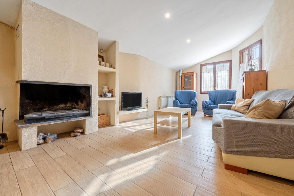 een woonkamer met een bank en een open haard bij Cal Marti in Farena