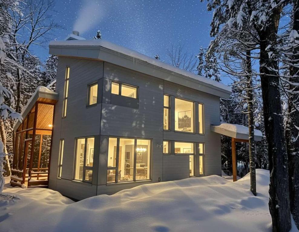 ein Haus im Schnee bei Nacht in der Unterkunft Ecology between forest and river - L'Hermine Charme in Saint-Raymond