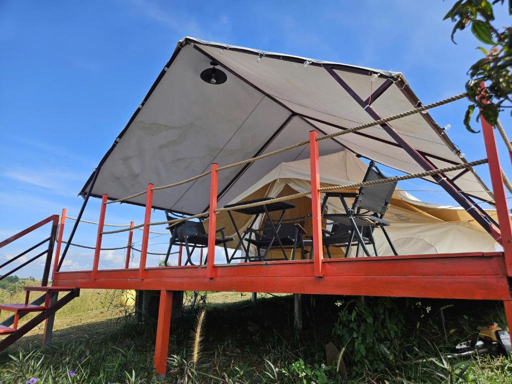 a tent with tables and chairs in a field at Danny Glamping Farm in Bảo Lộc