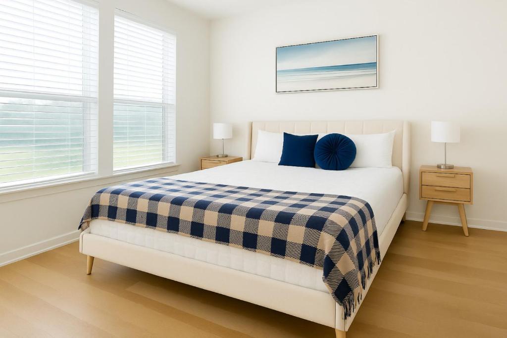 ein Schlafzimmer mit einem Bett mit einer blau-weißen Decke in der Unterkunft A plus Location WorkerFriendly KINGbed Pool Gym Modern in Sherman