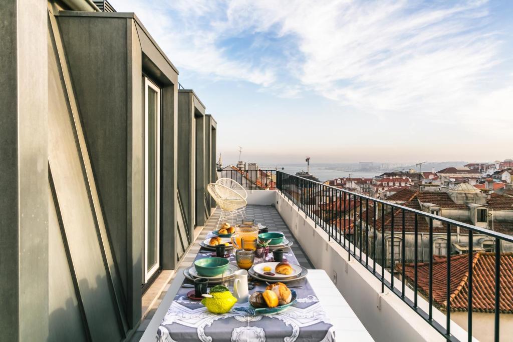 a table on a balcony with food on it at Almaria - Ex Libris Apartments | Chiado in Lisbon