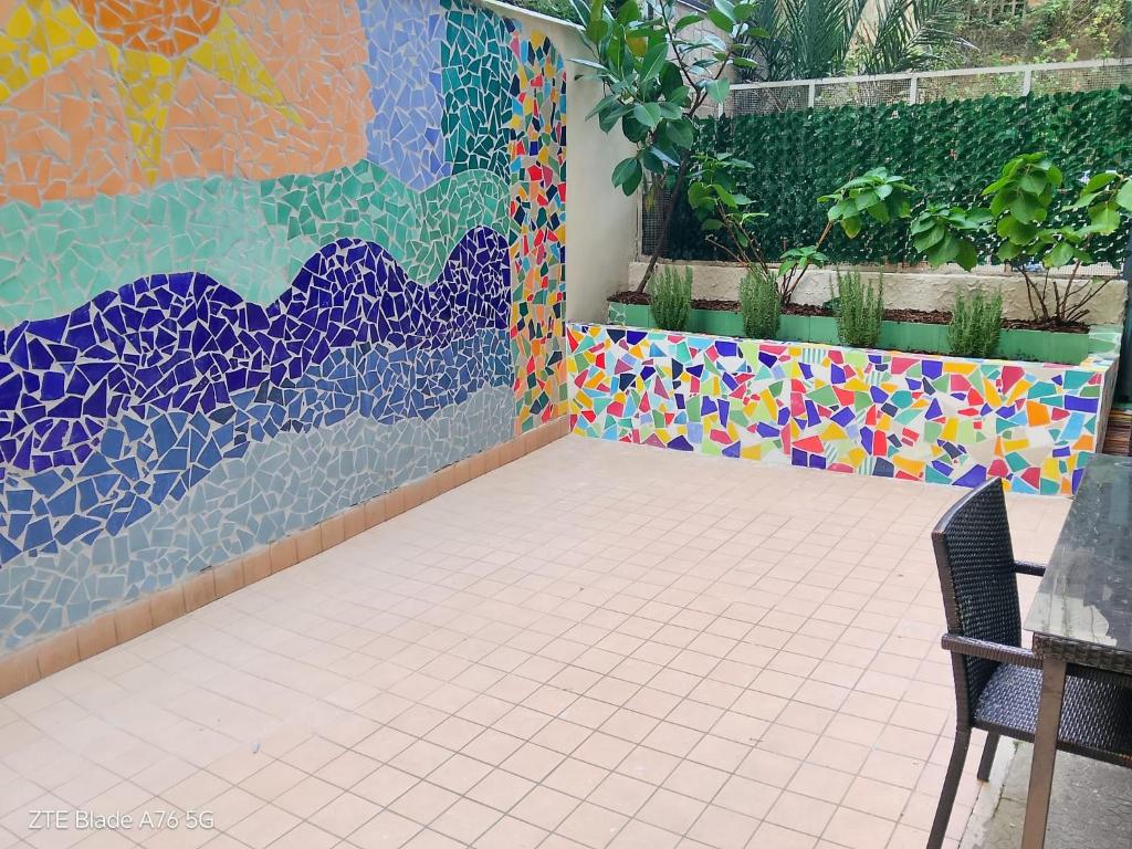 a patio with a colorful mosaic wall and a chair at Zia Lulù apartment in Salerno