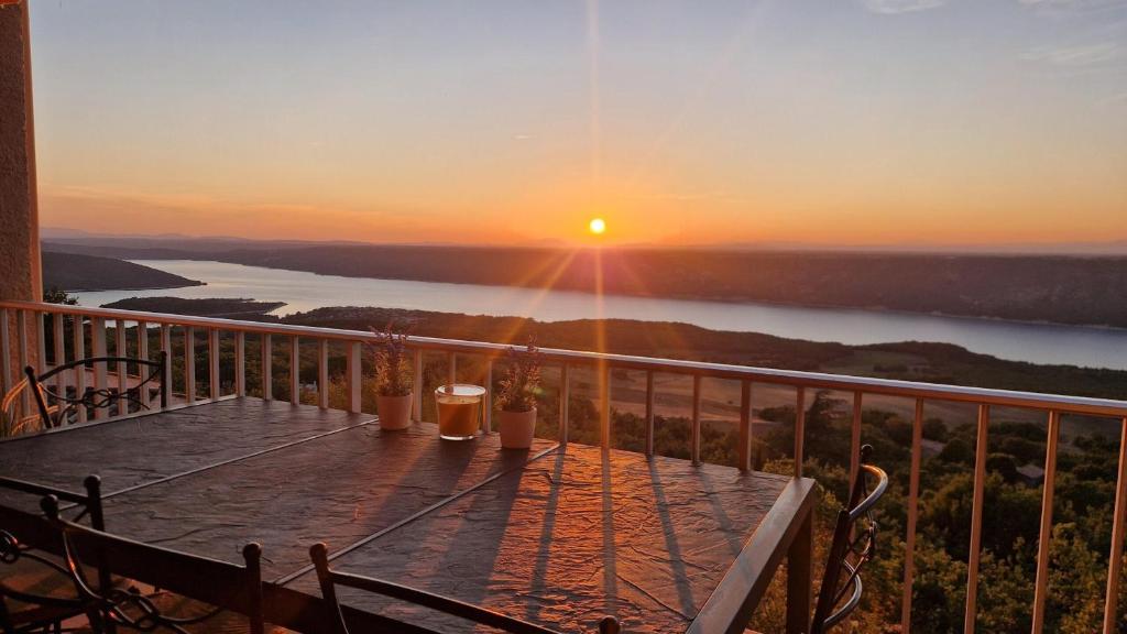 einen Balkon mit Blick auf einen See bei Sonnenuntergang in der Unterkunft Villa OVerdon in Aiguines