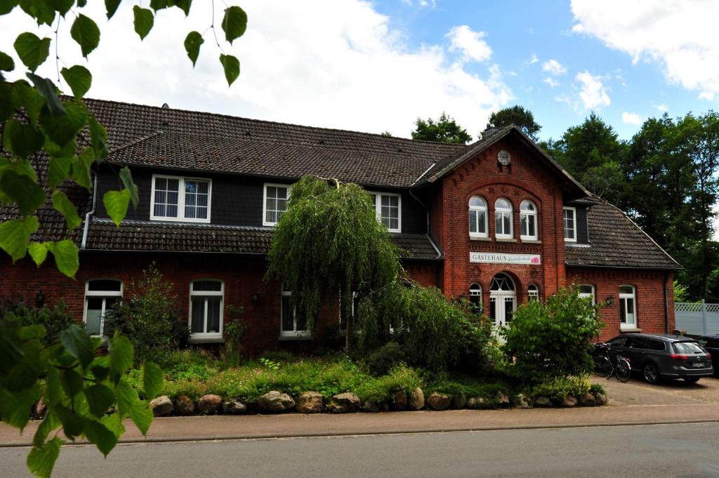 a red brick house with a black roof at Gästehaus Wacholderheide Garni in Eimke