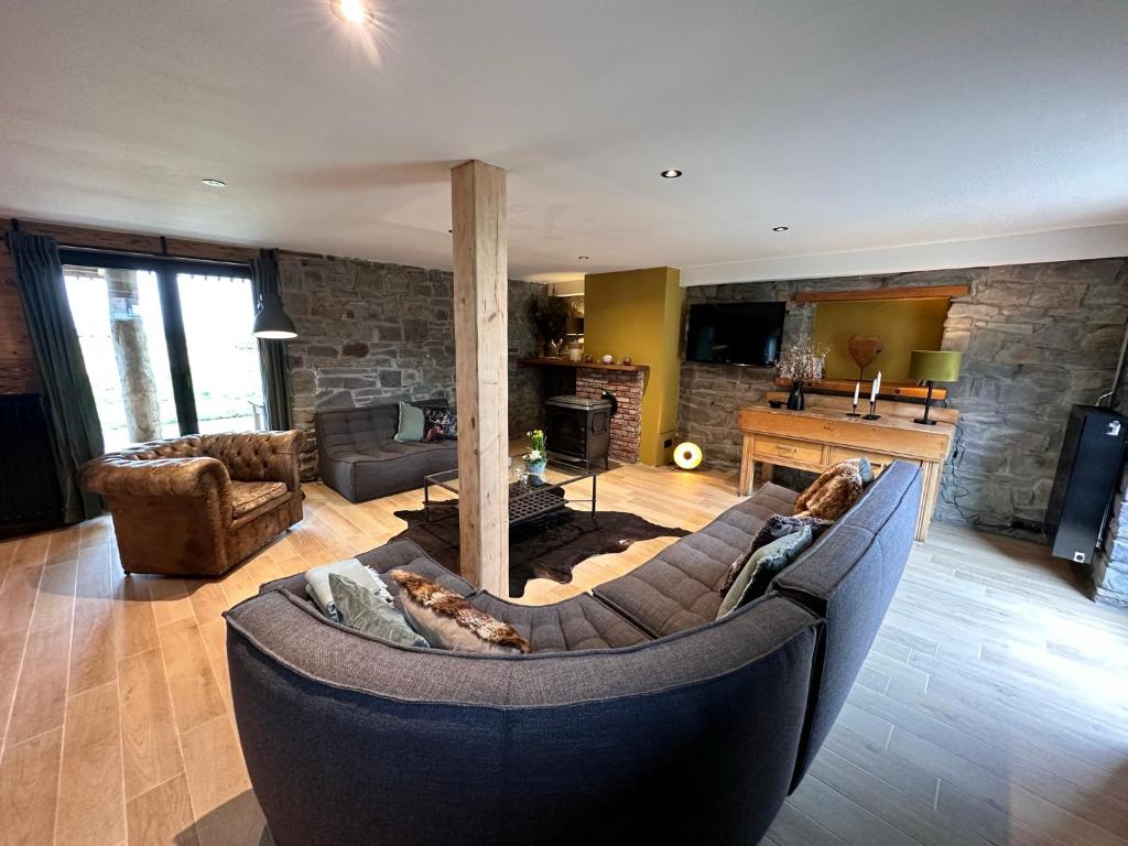 a living room with a couch and a fireplace at Domaine de Hurlevent - Gite 10 personnes - Le Refuge in Aywaille