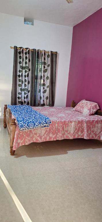ein Schlafzimmer mit einem Bett mit einer lila Wand in der Unterkunft Pearl farmstay in Kushālnagar