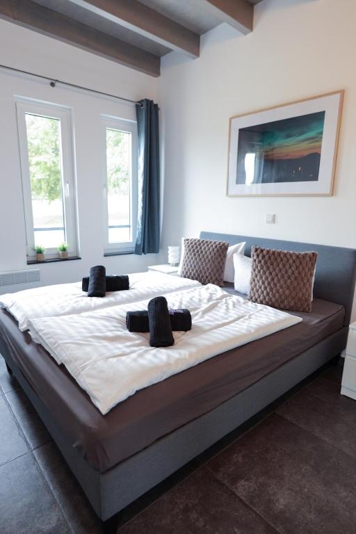 a large bed in a room with two windows at Ferienhaus Kisselblick in Bad Salzungen