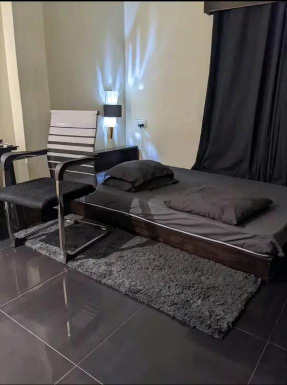 un letto e una sedia in una stanza di Edu Nibas a Dhaka