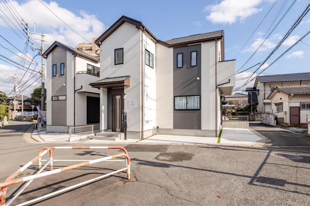a house with a gate in front of a street at Ganadan福岡南 in Fukuoka