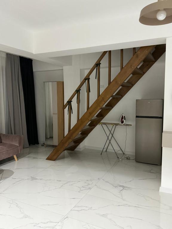 una scala in un soggiorno con divano e tavolo di ApartStudio28 Craiova a Craiova