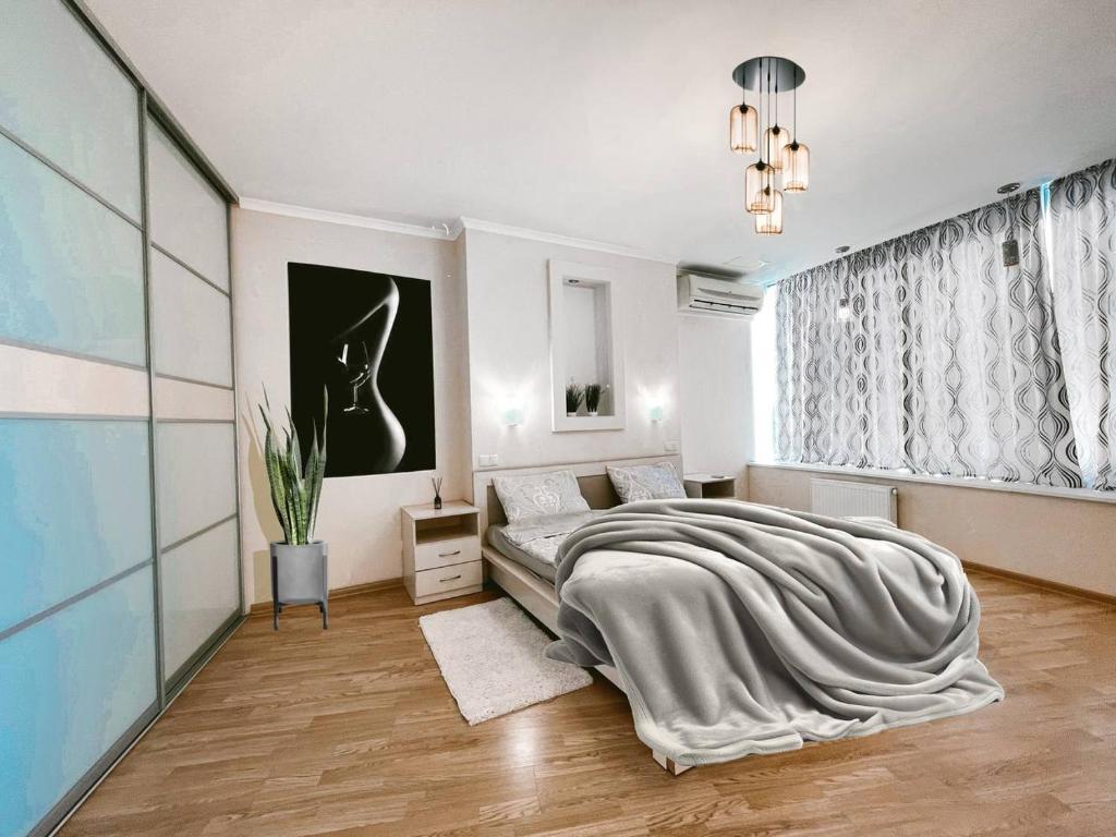 een witte slaapkamer met een groot bed en een raam bij Мост сити АПП 75 ЛЮКС in Dnipro