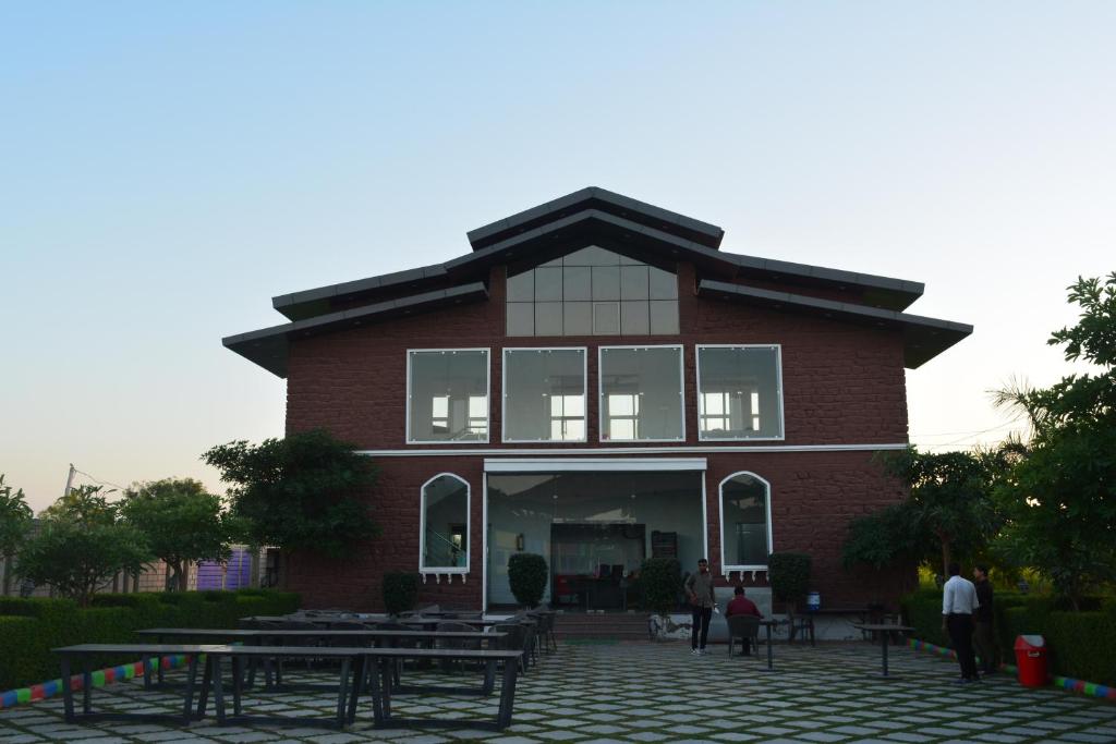 een rood bakstenen gebouw met mensen ervoor bij Mahi Baagh Resort in Pāli