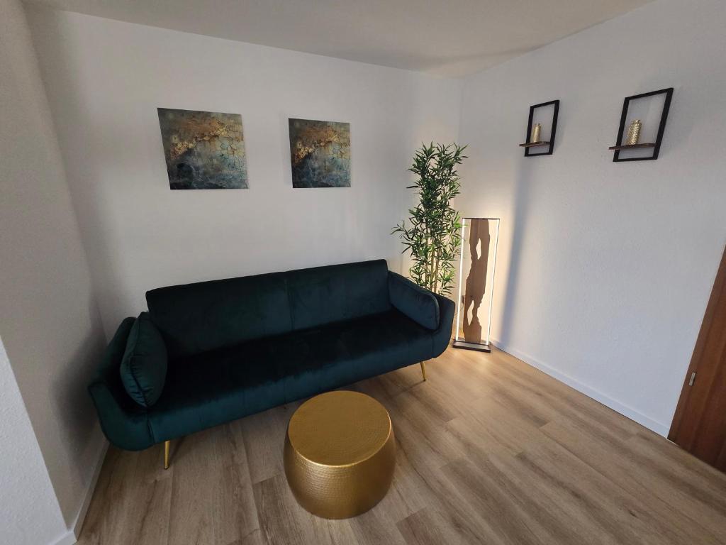 ein Wohnzimmer mit einer grünen Couch und einem Tisch in der Unterkunft WohnTraum Im Grünen in Dresden