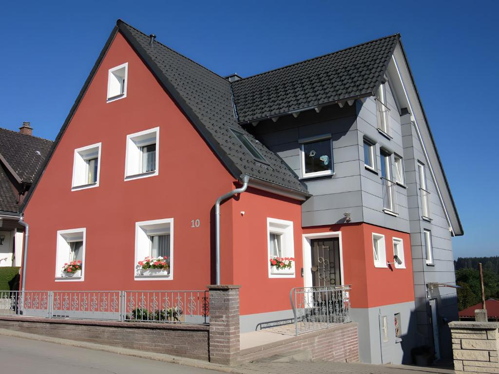 a red house with a black roof at Ferienwohnung Schuhmacher in Donaueschingen