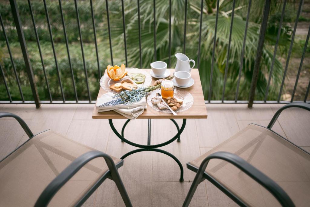 a table with a plate of food and two chairs at Il Vigneto Resort in Menfi