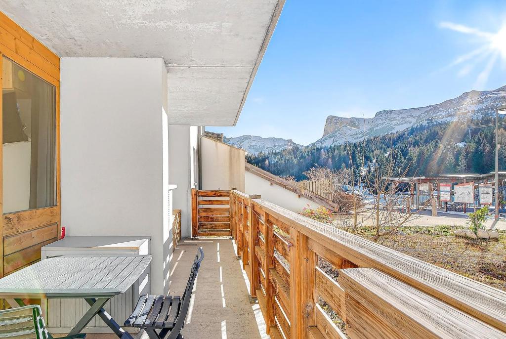 a balcony with a table and chairs and mountains at appartement Superdevoluy in Superdevoluy