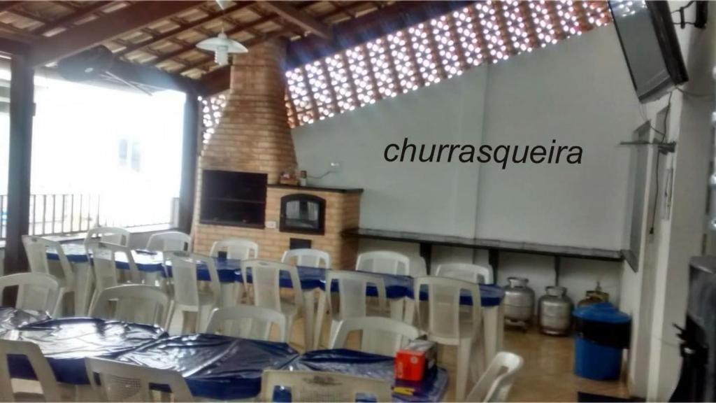 a dining room with a table and white chairs at Space Tour in Cabo Frio