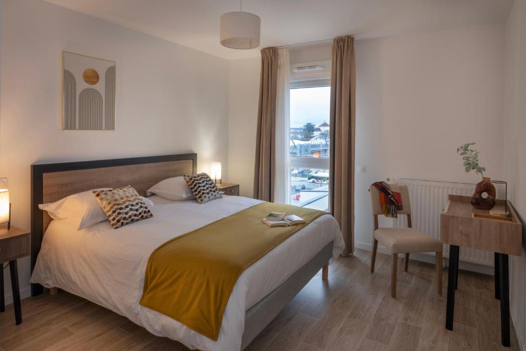 een slaapkamer met een groot bed en een raam bij DOMITYS - L'échiquier in Blois