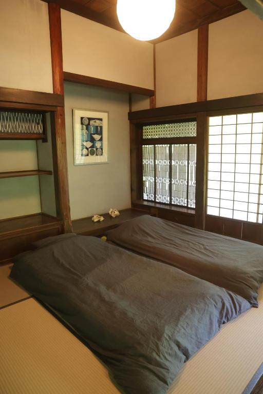 ein Schlafzimmer mit einem großen Bett in einem Zimmer in der Unterkunft BoBuchi in Ichihara