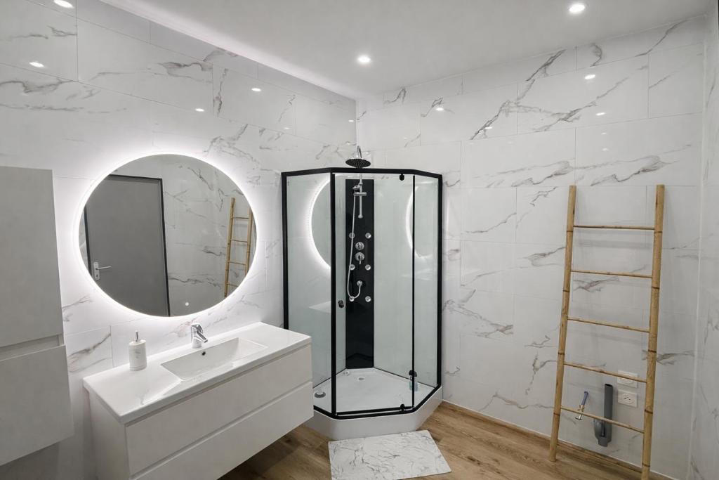 a bathroom with a shower and a sink and a mirror at Appart Hotel 23 - Le Cocon Creusois 2 in Guéret