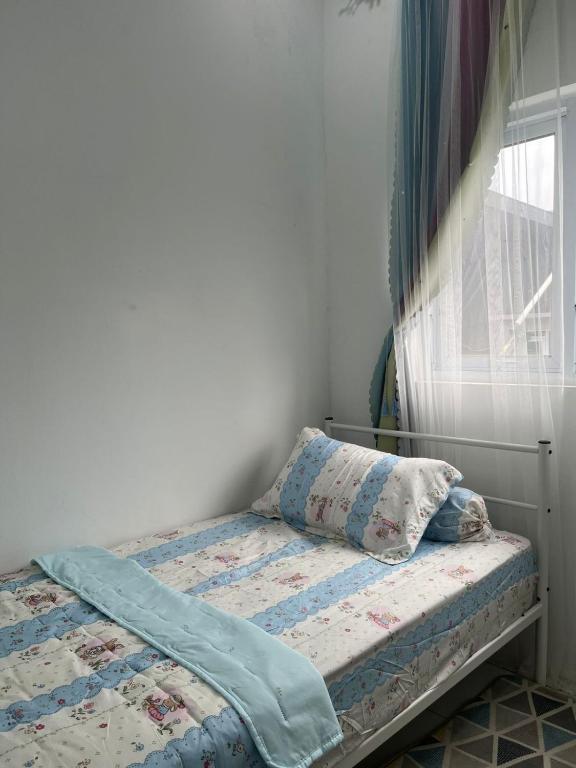 a bedroom with a bed with a pillow and a window at Homestay Rancabango A4 Garut in Tarogong