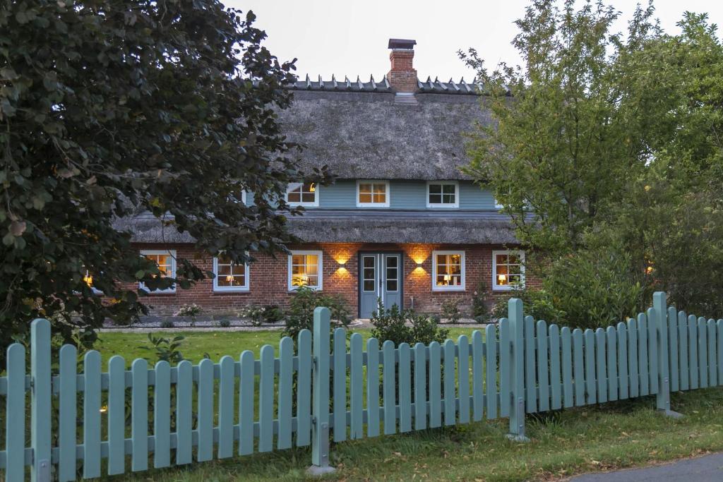 una staccionata bianca di fronte a una casa di Ferienwohnung Captains Lodge Steinbergkirche a Steinbergkirche