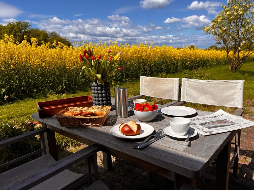 a picnic table with bread and a basket of fruit at Ferienwohnung Captains Lodge Steinbergkirche in Steinbergkirche