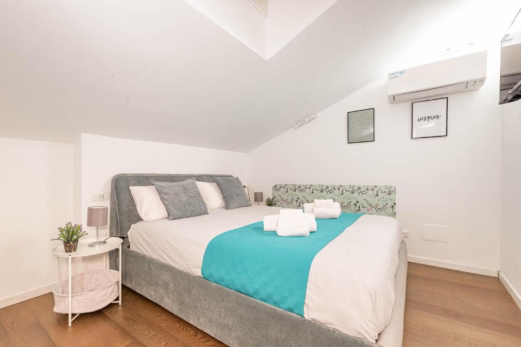 a white bedroom with a bed and a table at Italstay - Disciplini Duplex - 10 min dal Duomo in Milan