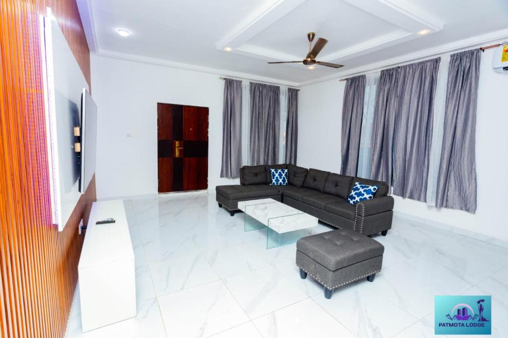 un soggiorno con un divano e un tavolo di Ernest homes a Kwabenyan