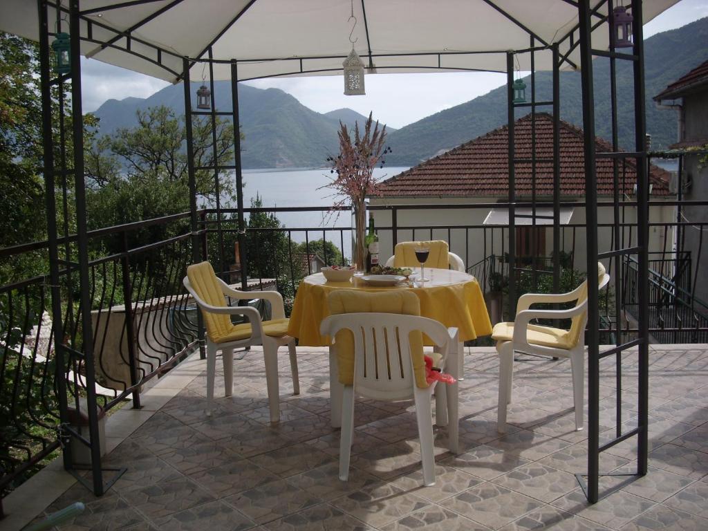 a table and chairs on a patio with a view at Holiday home Bokokotorski zaliv in Kotor