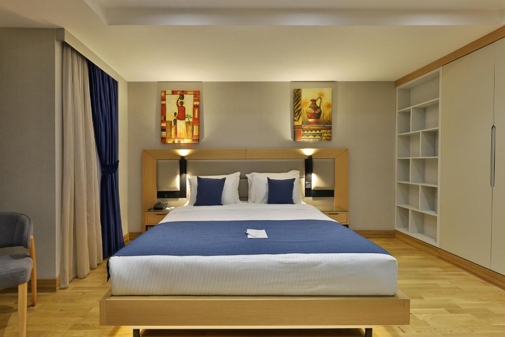 a bedroom with a large bed with blue sheets at Istanbul Taksim Pera Star Hotel - Istiklal Street in Istanbul