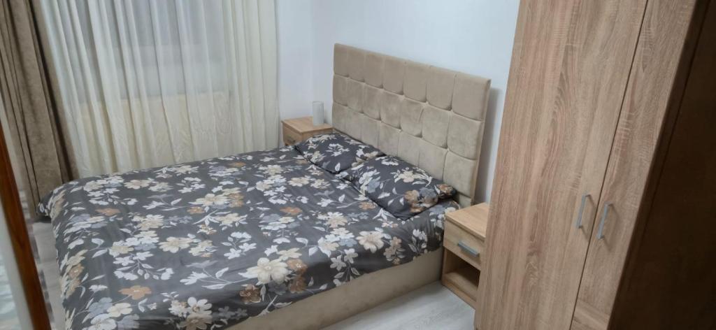 una camera da letto con un letto con copriletto floreale di E&A apartments a Târgu-Mureş